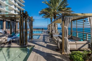 A poolside area with lounge chairs and a pool, overlooking the ocean. - Beachside Bliss: A Stylish Miami Apartment Steps from the Sand (Hollywood)