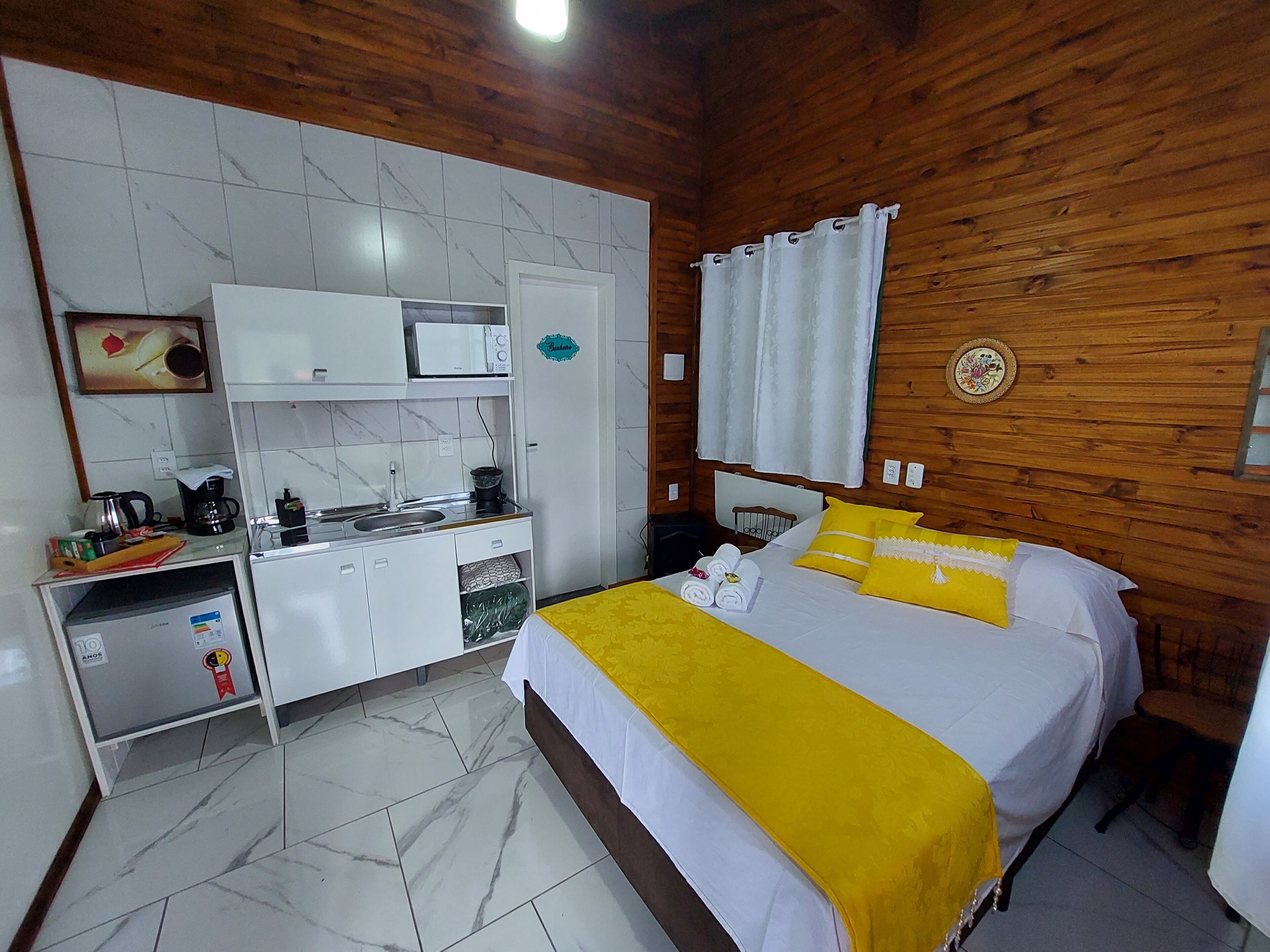 Una camera compatta con un letto, angolo cottura e bagno.