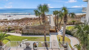 Une propriété située en bord de mer, dotée d’une terrasse en bois, d’un espace barbecue et offrant une vue sur l’océan.