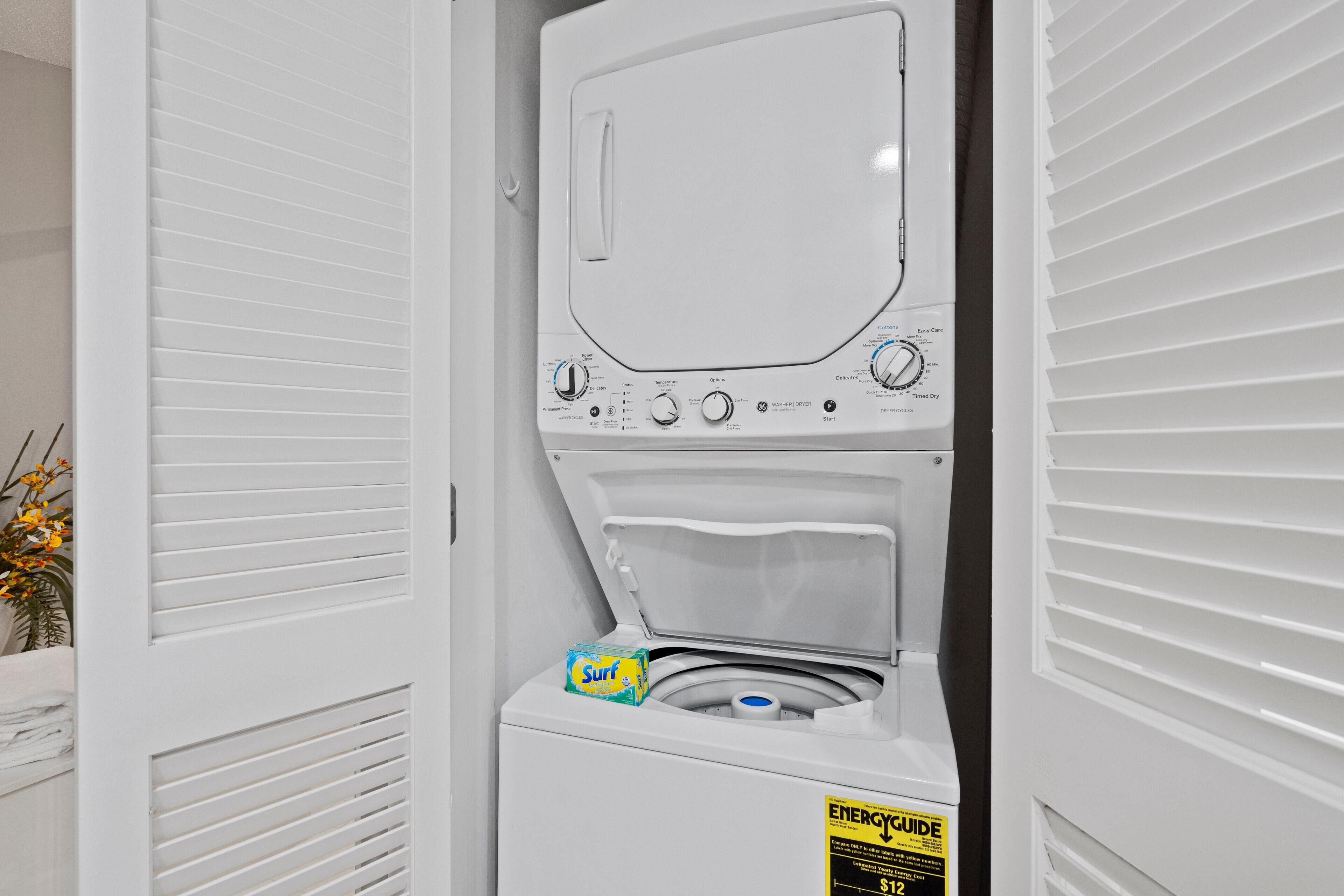 A compact washer and dryer unit with a control panel, a detergent box, and an energy efficiency label.