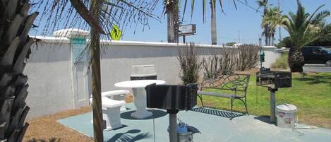 A patio area with outdoor seating, a trash can, and a mailbox.