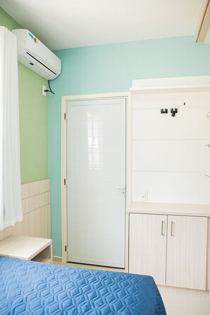 Ein Schlafzimmer mit Bett, Kleiderschrank und Klimaanlage.
