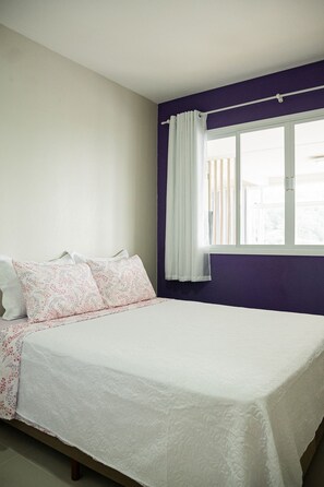 A bedroom with a bed, a window with curtains, and a view of the outside. - Morada Monte Verde - Florianópolis-SC (Florianópolis)