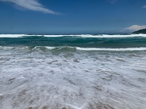 Ein Strand mit Wellen und blauem Himmel.