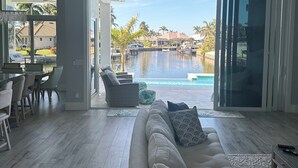 Amplia sala de estar con un sofá grande, un comedor y vistas a una piscina.