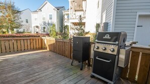 Una terraza con una parrilla y un mueble de almacenamiento.