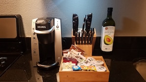 Eine Küche mit einer Keurig-Kaffeemaschine, einem Messerblock und einer Flasche Avocadoöl.