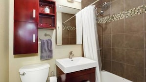 Ein Badezimmer mit Toilette, Waschbecken, Spiegel und Dusche.
