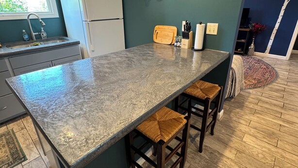 A kitchen with a granite island, wooden stools, a refrigerator, and a window with blinds. - Charming 2-bedroom apartment in superb Bennington with WiFi (Bennington)