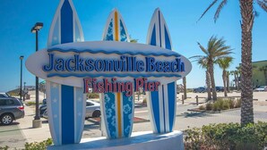 A sign for Jacksonville Beach Fishing Pier with surfboard designs. - Entire JAX Beach Bungalow 7 blocks from Ocean (Jacksonville Beach)