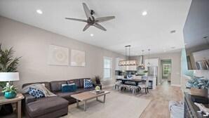 A spacious living room with a sofa, coffee table, and a ceiling fan.