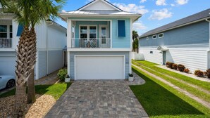 A two-story house with a front garage, a balcony, and a well-maintained lawn.