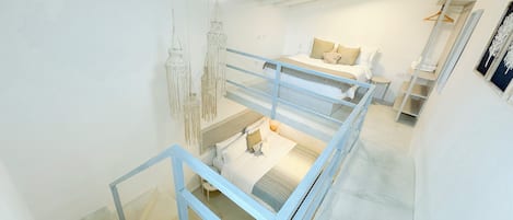 Un interior moderno con una escalera, una cama y una decoración de macramé colgante.