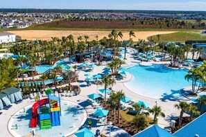 Ein Resort mit großem Pool, Wasserrutschen und Palmen.