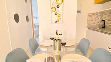 Un comedor moderno con una mesa de vidrio, sillas azules y una pieza decorativa sobre la mesa.