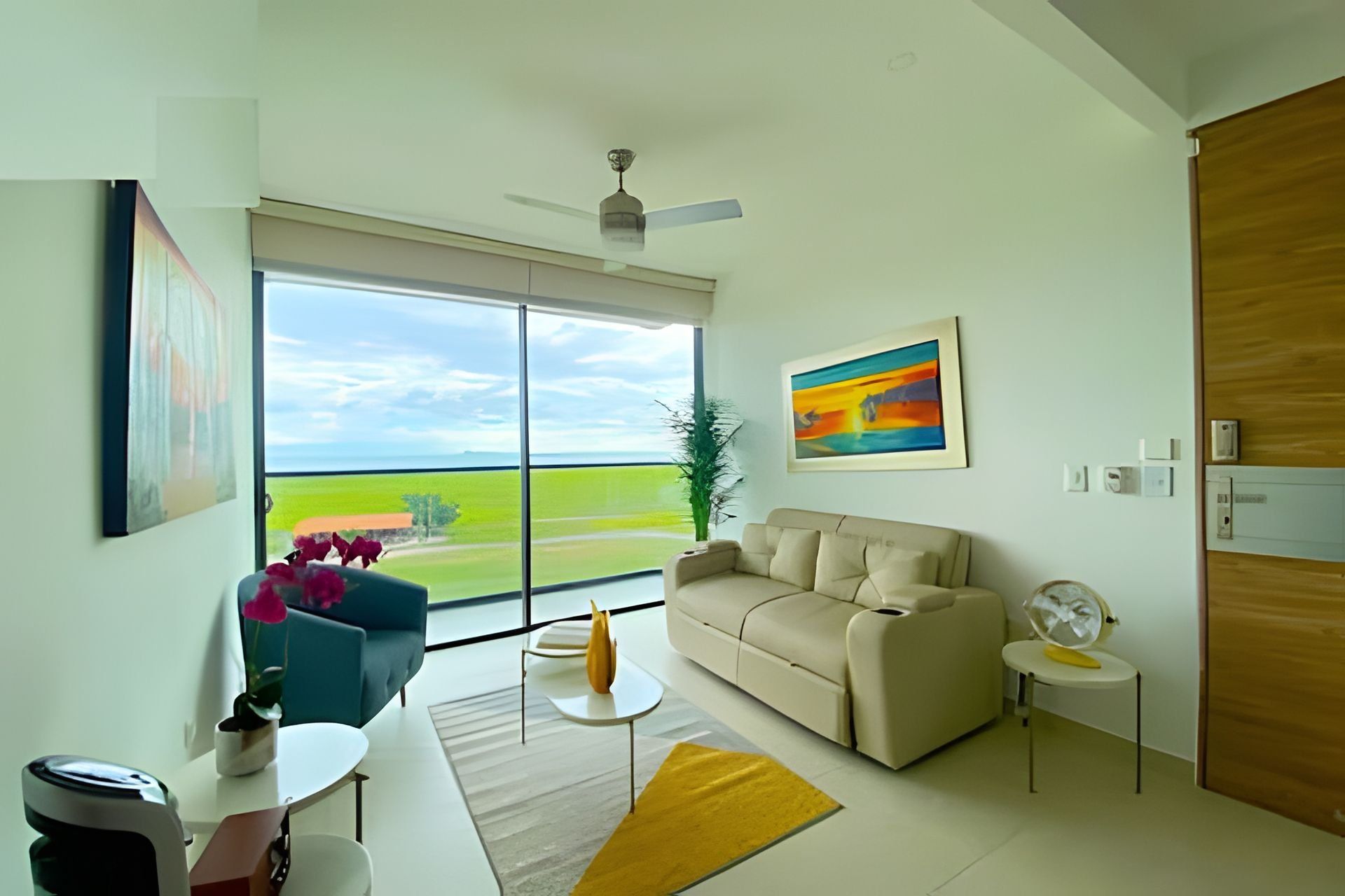 A modern living room with a large window, a ceiling fan, a beige sofa, a small round table, and a potted plant.