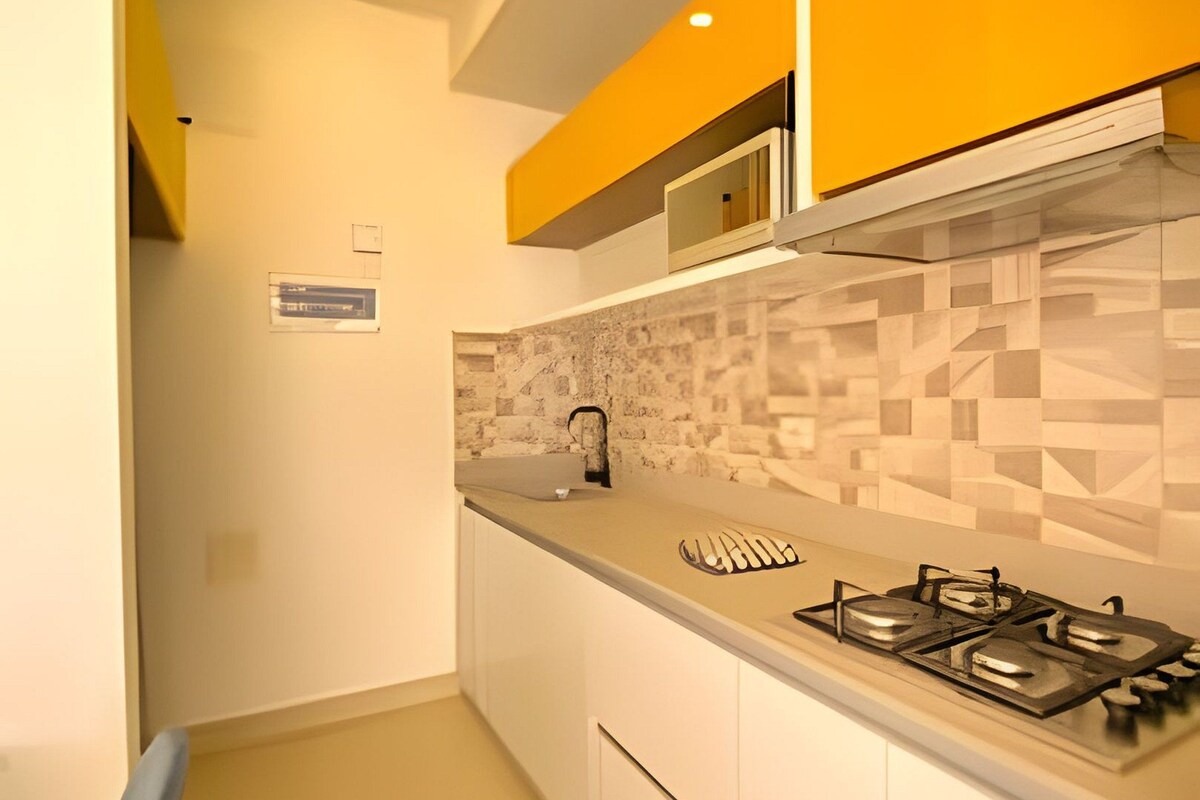 A modern kitchen with white cabinets, a gas stove, and a microwave.