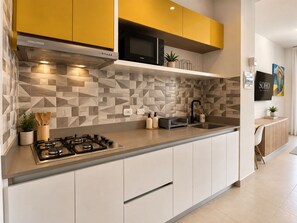Une cuisine moderne équipée d’une cuisinière à gaz, d’un four à micro-ondes et d’un évier.