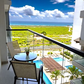 A balcony with a view of a pool and a landscape. - Apartamentos Salinas del Mar - by SOHO (Santa Marta)