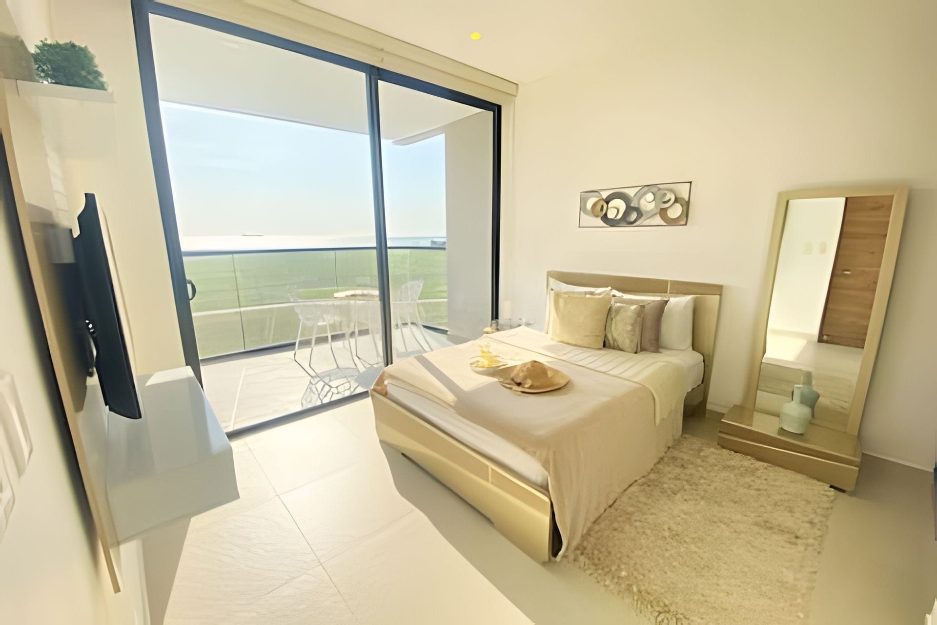 Een moderne slaapkamer met een groot bed, een nachtkastje, een spiegel en uitzicht op de omgeving via een schuifdeur.