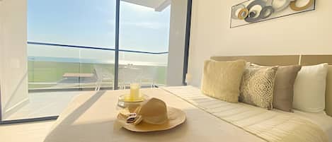 A modern bedroom with a large bed, a view of the outdoors, and a minimalist decor.