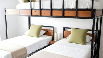 Une chambre avec un lit superposé, comprenant deux lits, une table de chevet et un climatiseur fixé au mur.