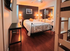 Relax in this serene bedroom with a large bed, bedside tables, and a decorative headboard.