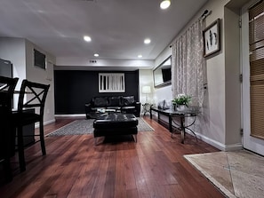 Relax in this stylish living room with a comfortable sofa, dining area, and large flat-screen TV.