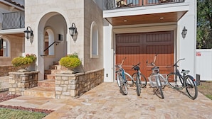A house with a stone facade, a wooden balcony, and a garage with a brown door.