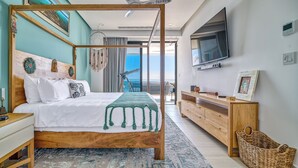 Une chambre à coucher avec un lit à baldaquin, une commode en bois, une télévision et une vue sur la mer.