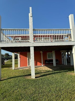 A two-story building with a balcony and a covered patio area.