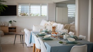 A dining area with a table set for four, including plates, glasses, and cutlery.