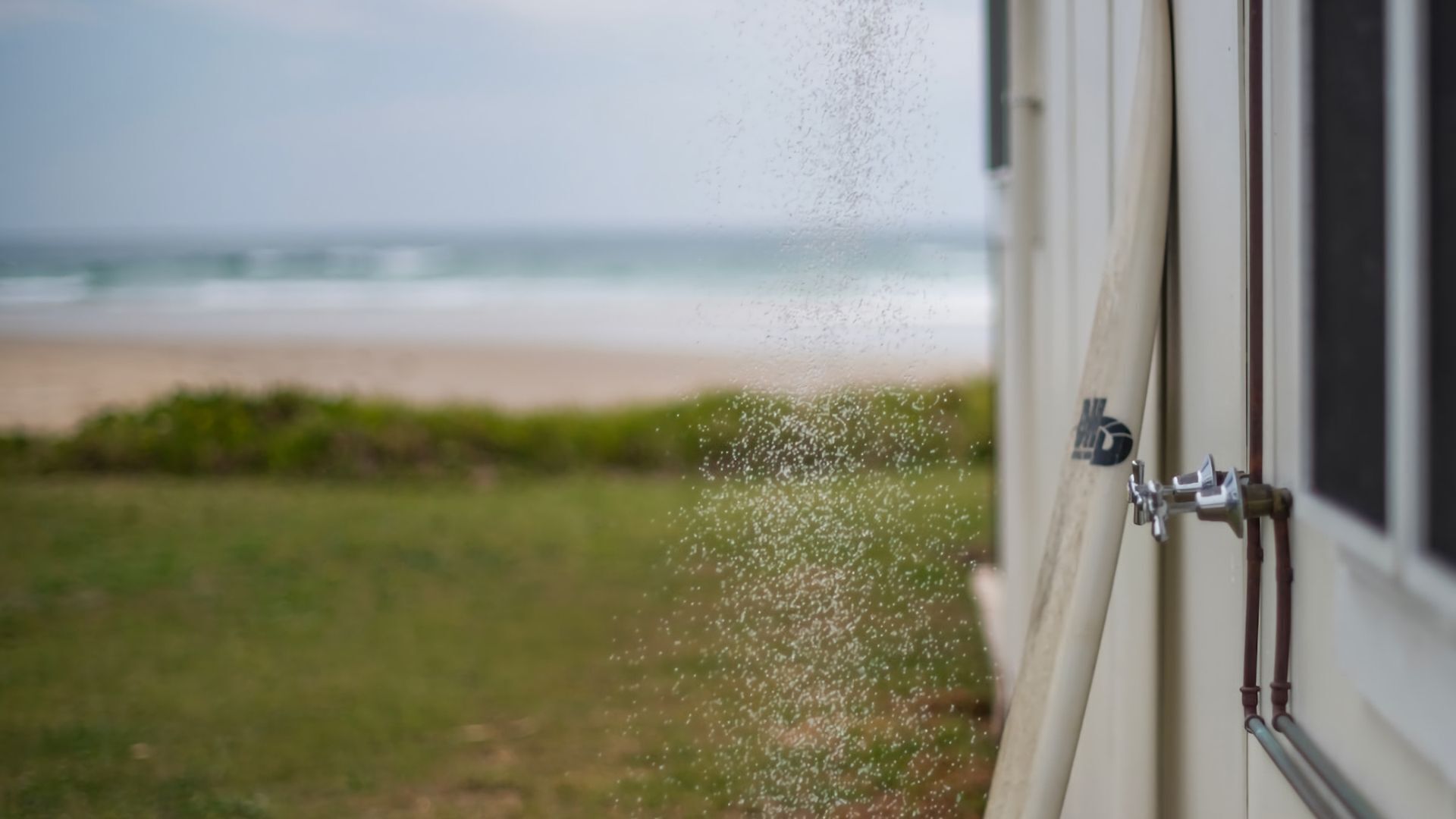 Una finestra con vista su spiaggia e oceano.