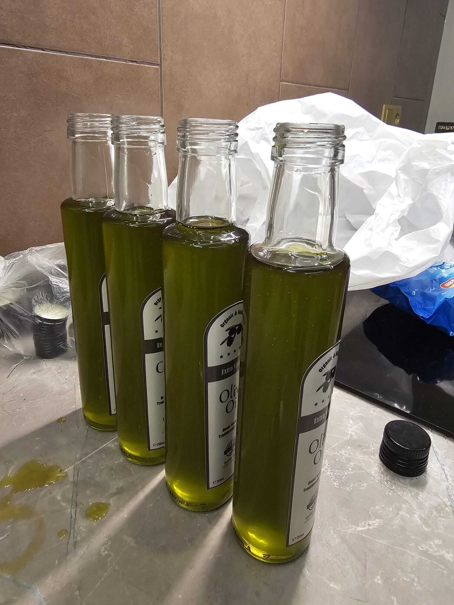 Several glass bottles with labels, some with caps, on a tiled surface.