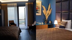 Camera d'albergo con due letti, una scrivania, una sedia, vista attraverso una porta e una pianta decorativa.