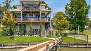 A multi-story hotel with a wooden deck extending over a body of water.