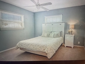 Cozy retreat with a single bed, ceiling fan, and window with blinds.