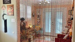 Ein Zimmer mit einem dekorativen Vorhang, einem Teppich und einem Sessel.