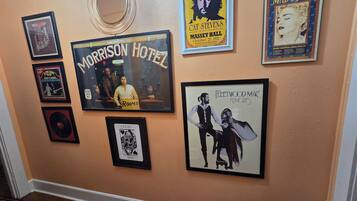 A wall with various framed posters and a mirror.