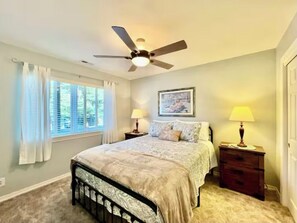 Cozy retreat with a single bed, ceiling fan, and bedside tables.