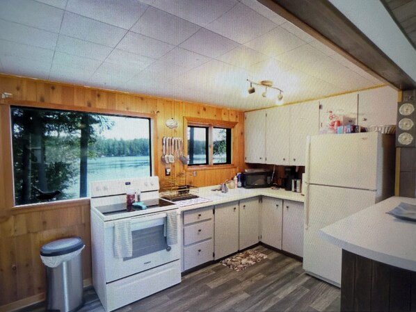 A compact kitchen with wooden cabinets, a microwave, and a sink.