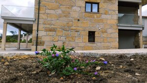 A stone building with a balcony and a small window.