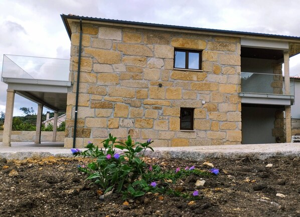 A stone building with a balcony and a small window.
