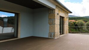 A modern building with a stone exterior, large glass windows, and a flat roof.