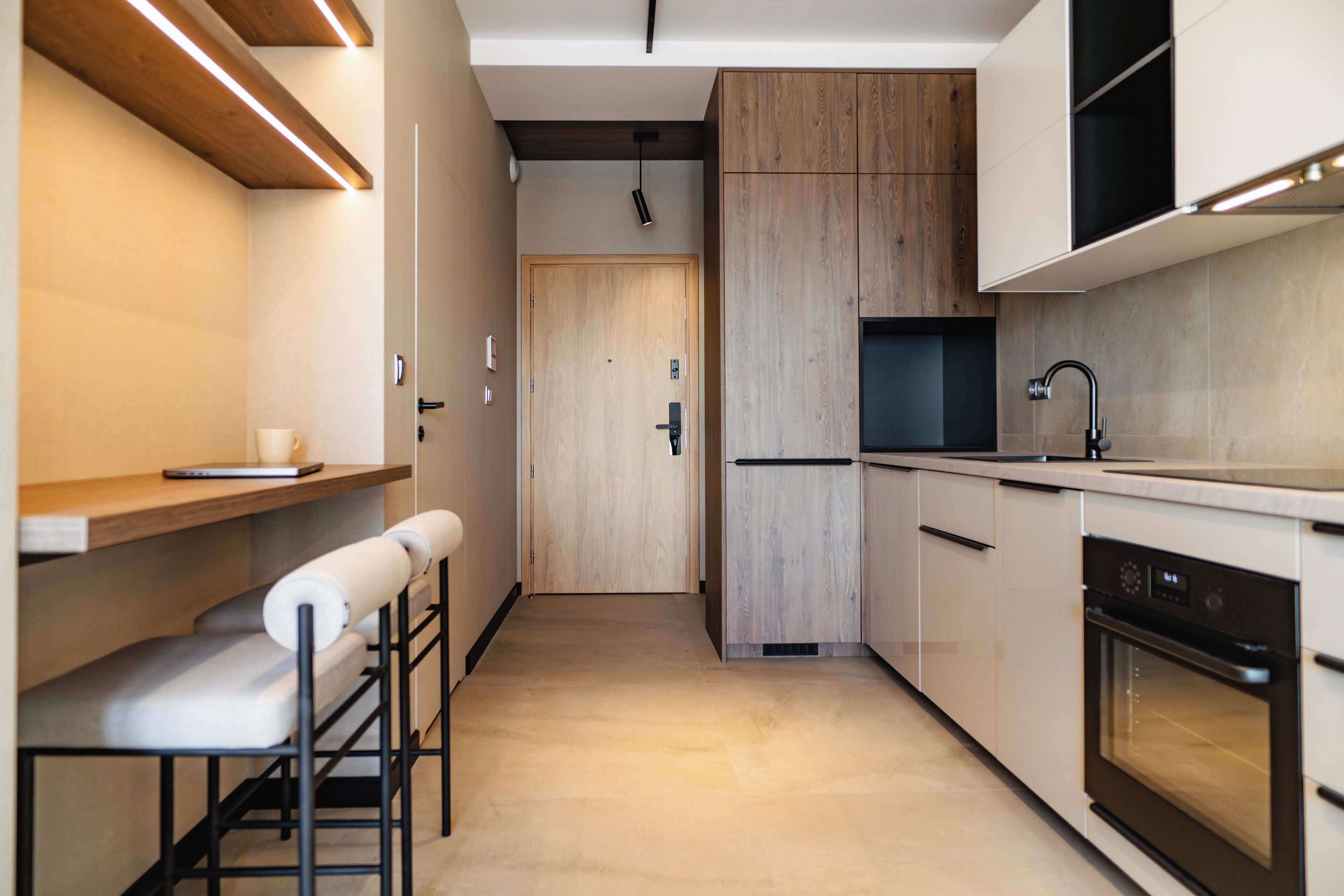 A modern kitchen with wooden cabinets, a built-in oven, and a countertop.