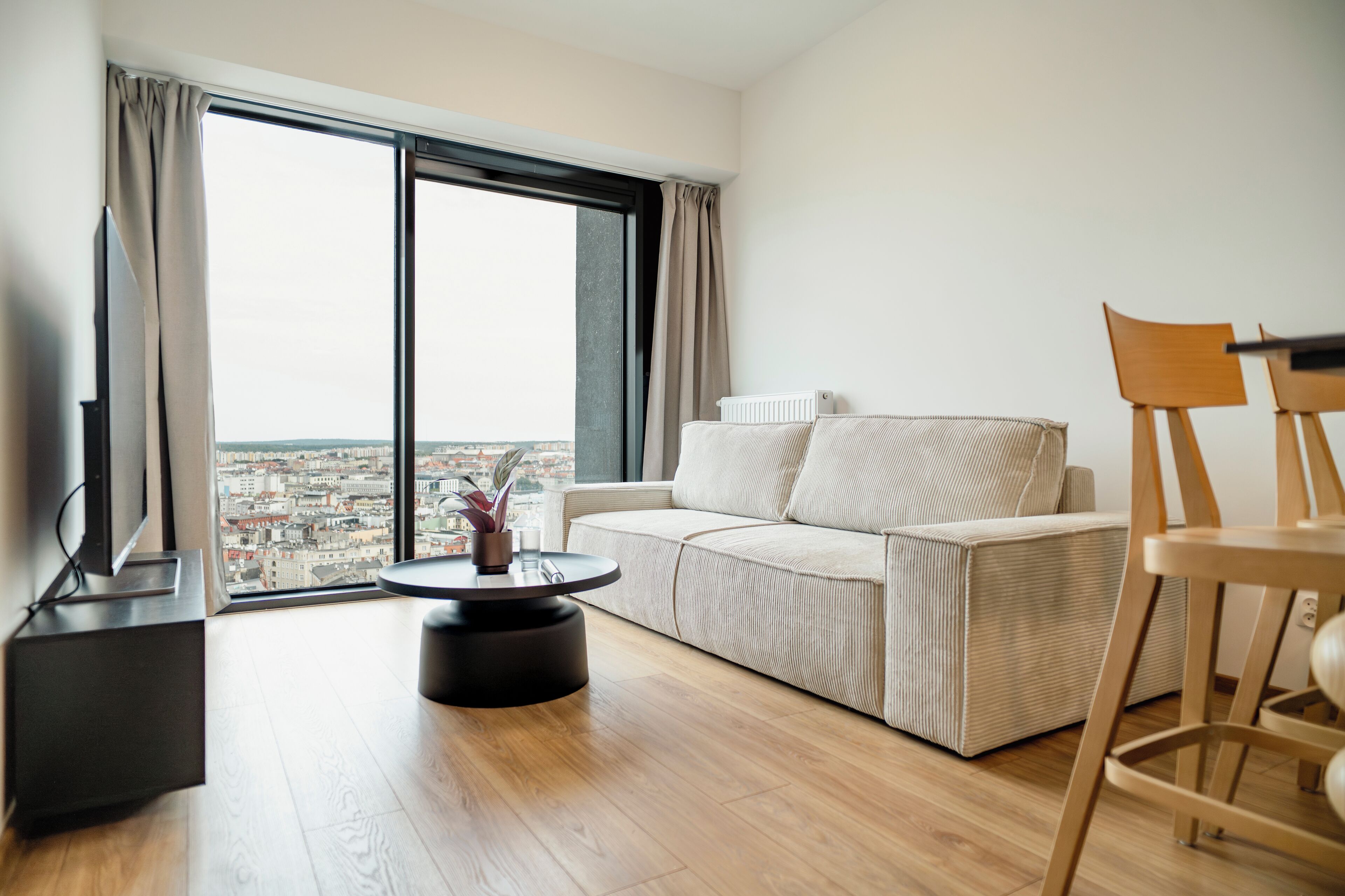 A modern living room with a sofa, a coffee table, and a TV.
