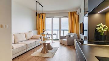 A modern living room with a sofa, coffee table, and a view of the outdoors.