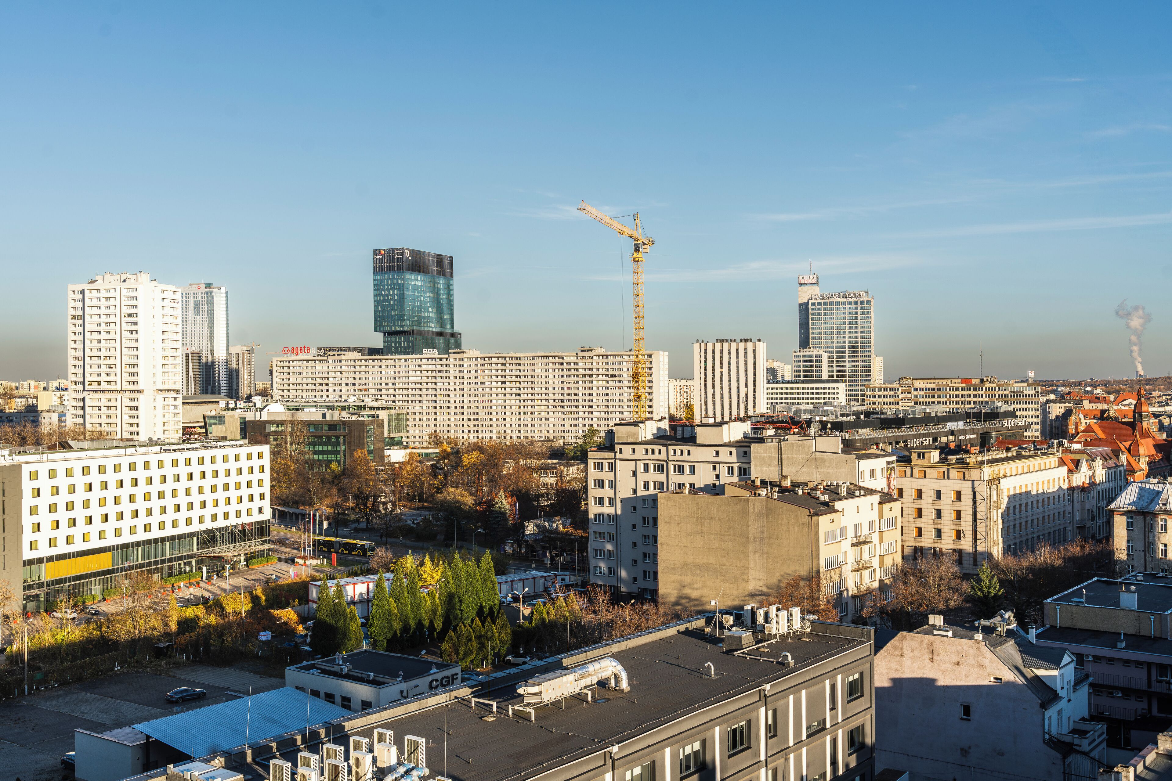 A cityscape with various buildings, including a large hotel with a modern design and multiple floors.
