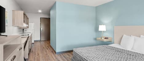 A modern hotel room with a bed, bedside table, and a TV.