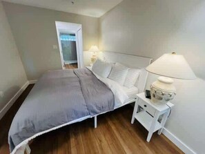 Une chambre à coucher avec un lit, des tables de chevet et une commode.